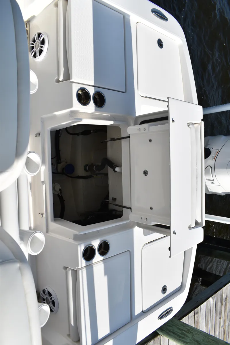 Slide: The Image of 2024 Regulator 26XO boat deck with storage compartments and engine access. - 19