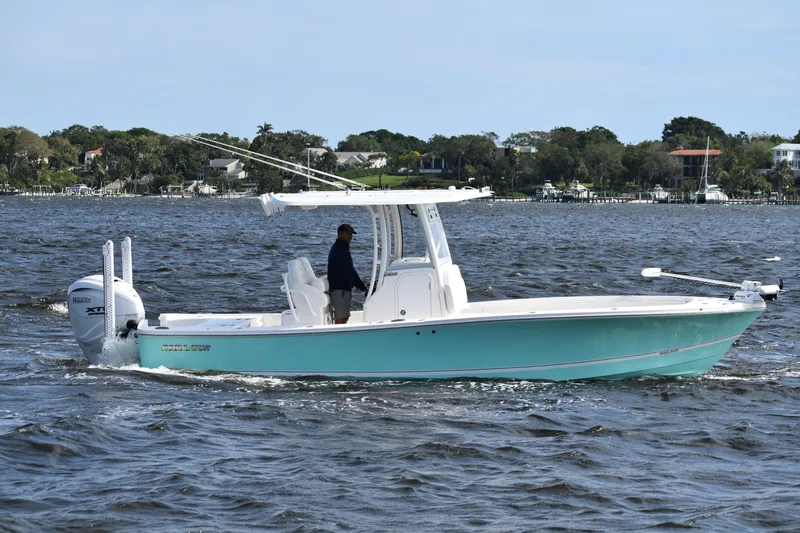 Slide: The Image of 2024 Regulator 26XO boat cruising on a scenic waterway. - 2