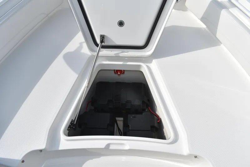 Slide: The Image of 2024 Regulator 26XO boat storage compartment with open hatch and visible battery setup. - 20
