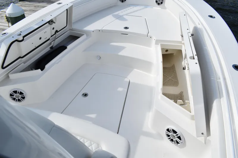Slide: The Image of 2024 Regulator 26XO boat interior with open storage compartments and speakers. - 24
