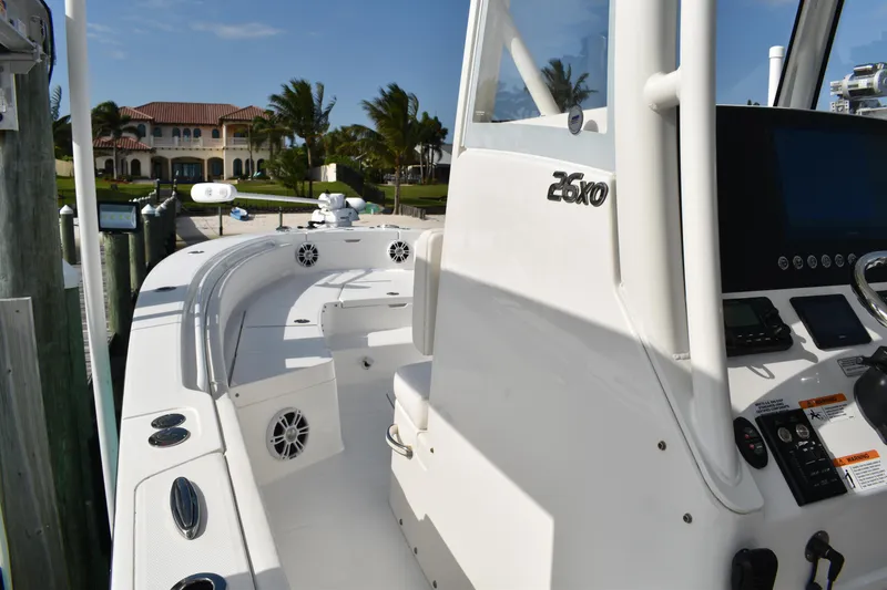 Slide: The Image of 2024 Regulator 26XO boat interior with console and seating, docked near waterfront property. - 6