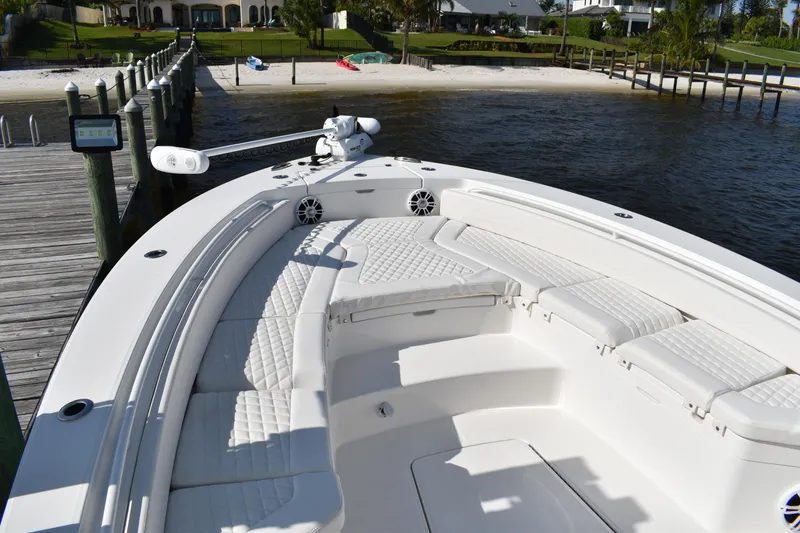 Slide: The Image of 2024 Regulator 26XO boat with spacious seating, docked by a serene waterfront. - 8