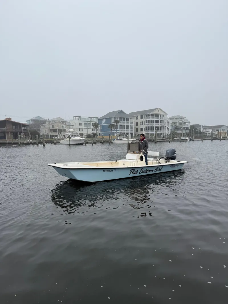 Slide: The Image of 2005 Jones Brothers 22 Bateau boat on water with coastal buildings in the background. - 2