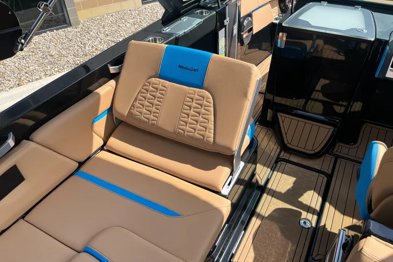 Slide: The Image of 2022 MasterCraft X26 boat interior with tan and blue seating, showcasing luxury design. - 12
