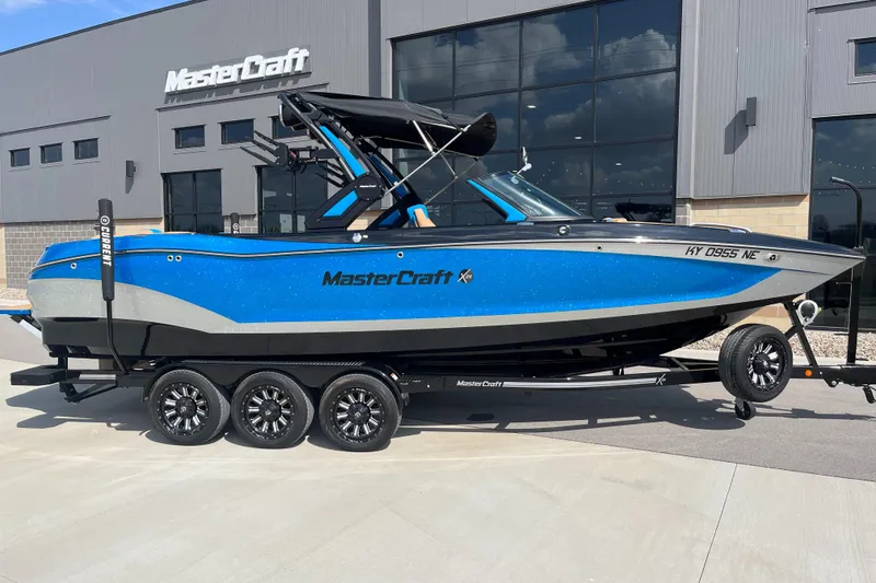 Slide: The Image of 2022 MasterCraft X26 boat in blue, parked on a trailer outside a MasterCraft building. - 3