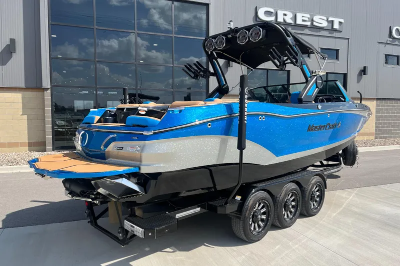 Slide: The Image of 2022 MasterCraft X26 boat in blue, parked on a trailer outside a building. - 4