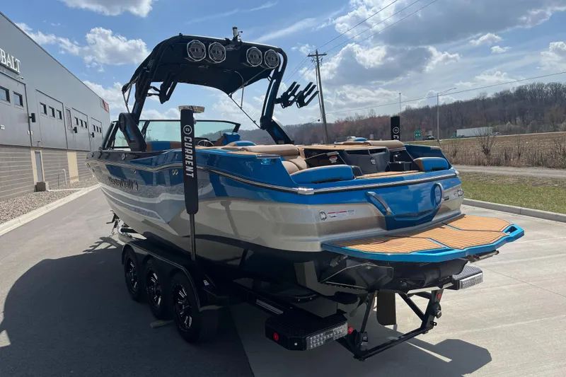 Slide: The Image of 2022 MasterCraft X26 boat on trailer, blue and white design, parked outdoors. - 7
