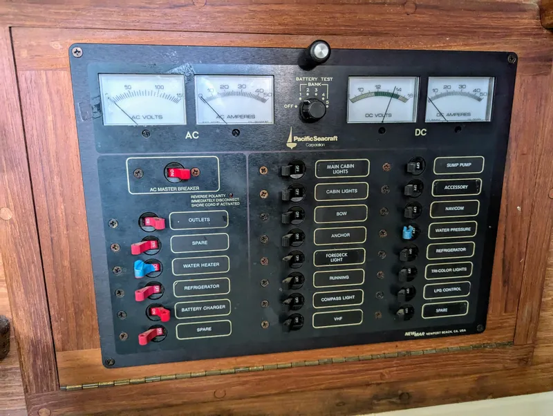 Slide: The Image of Electrical control panel of a 1995 Pacific Seacraft 34 sailboat with AC and DC meters. - 49
