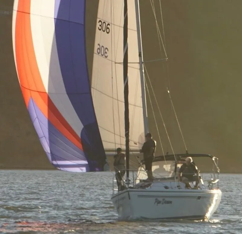 Slide: The Image of Sailboat Catalina 310, 2005 model, with colorful spinnaker on calm water. - 1
