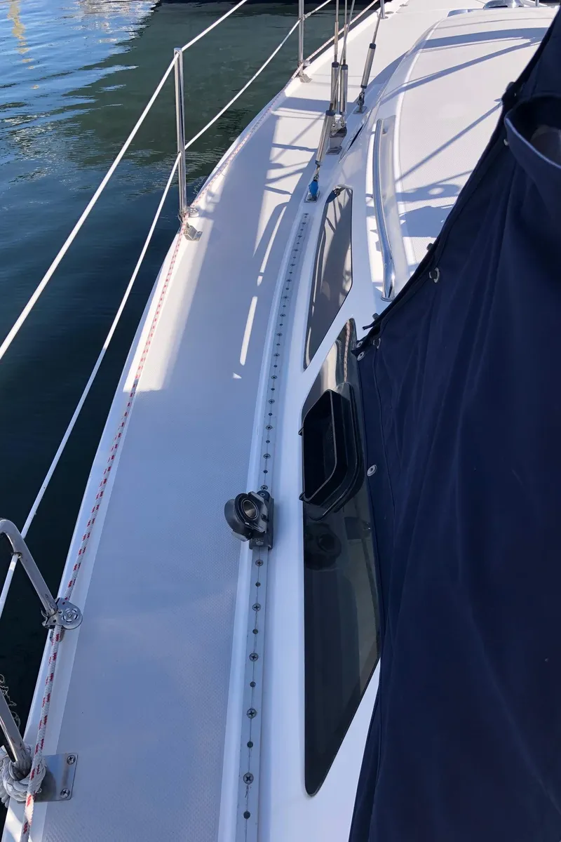 Slide: The Image of 2005 Catalina 310 sailboat deck view with railing and blue cover. - 16