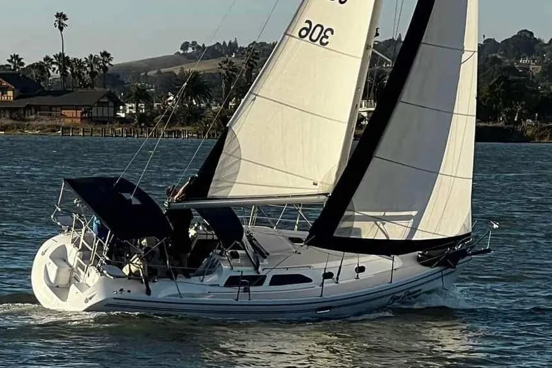 Slide: The Image of Sailing Catalina 310 yacht from 2005 on a serene waterway. - 2