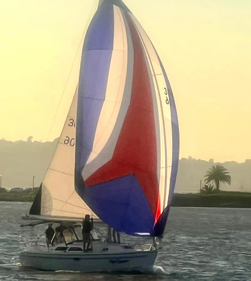Slide: The Image of 2005 Catalina 310 sailboat with colorful spinnaker sailing on a sunny day. - 24