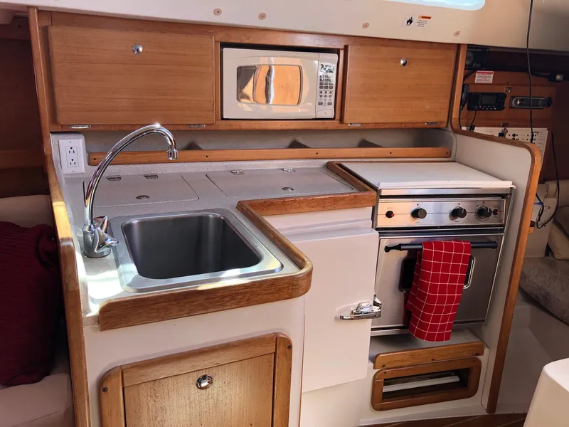 Slide: The Image of 2005 Catalina 310 yacht kitchen with sink, stove, and microwave. - 7