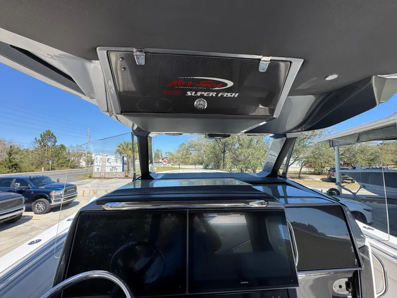 Slide: The Image of 2018 Nor-Tech 452 Super Fish boat dashboard with navigation screens and overhead storage. - 35