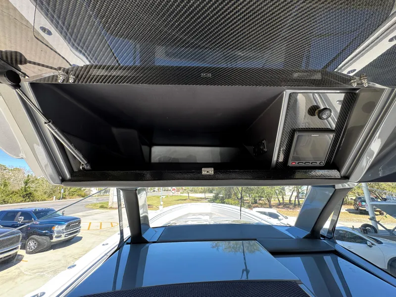 Slide: The Image of 2018 Nor-Tech 452 Super Fish boat dashboard with open storage compartment and control panel. - 36