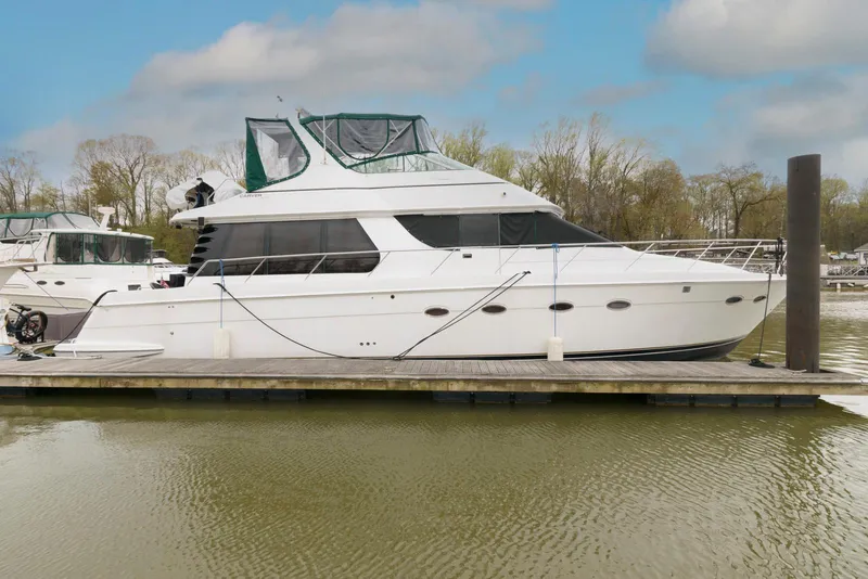 Slide: The Image of 2000 Carver 530 Voyager Pilothouse yacht docked on calm water. - 0