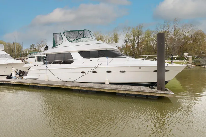Slide: The Image of 2000 Carver 530 Voyager Pilothouse yacht docked on a calm river. - 1