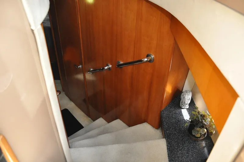 Slide: The Image of Interior stairs of 2000 Carver 530 Voyager Pilothouse with wooden doors and carpeted steps. - 25