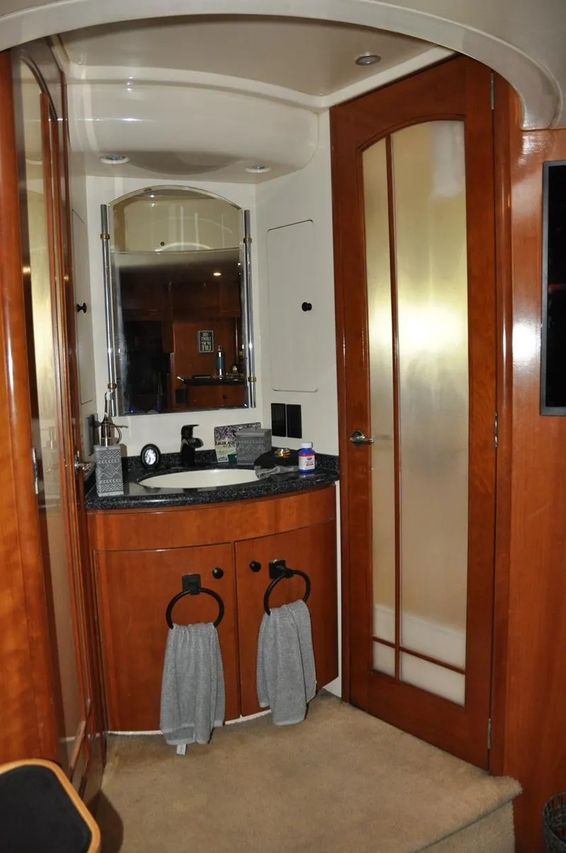 Slide: The Image of 2000 Carver 530 Voyager Pilothouse bathroom with wood cabinetry and frosted glass door. - 28