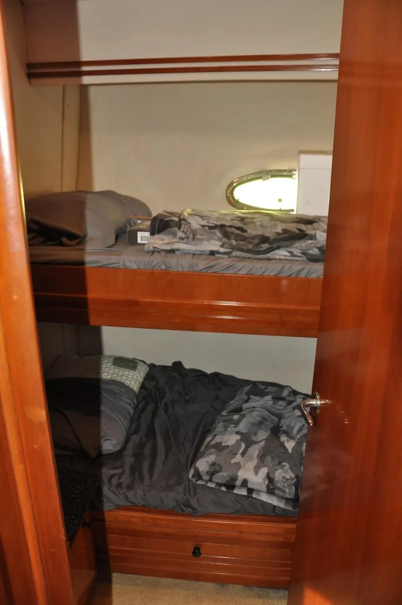 Slide: The Image of Bunk beds in 2000 Carver 530 Voyager Pilothouse, featuring wooden interior and porthole window. - 31