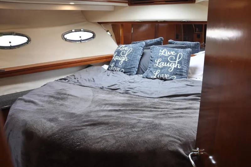 Slide: The Image of Cozy bedroom in 2000 Carver 530 Voyager Pilothouse with decorative pillows and porthole windows. - 32