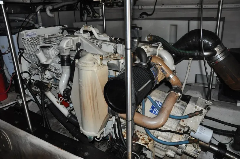Slide: The Image of Engine room of 2000 Carver 530 Voyager Pilothouse, showcasing mechanical components and piping. - 36
