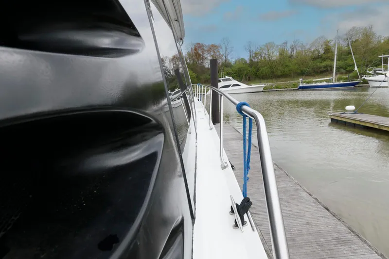 Slide: The Image of Carver 530 Voyager Pilothouse 2000 docked by a serene marina with lush greenery. - 4
