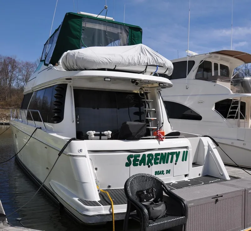 Slide: The Image of 2000 Carver 530 Voyager Pilothouse yacht docked, named "SEARENITY II," with green canopy. - 8