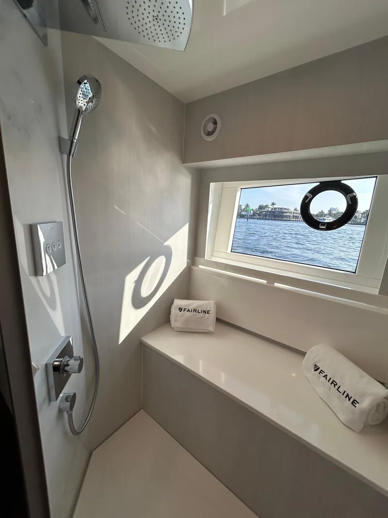 Slide: The Image of 2024 Fairline Squadron 68 yacht bathroom with modern shower and window view. - 15