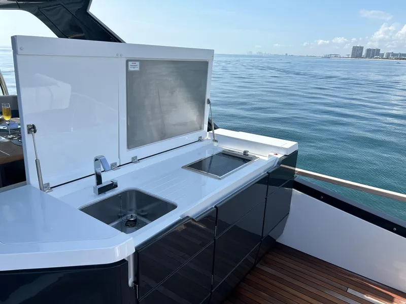 Slide: The Image of 2024 Fairline Squadron 68 yacht with sleek outdoor kitchen and ocean view. - 25