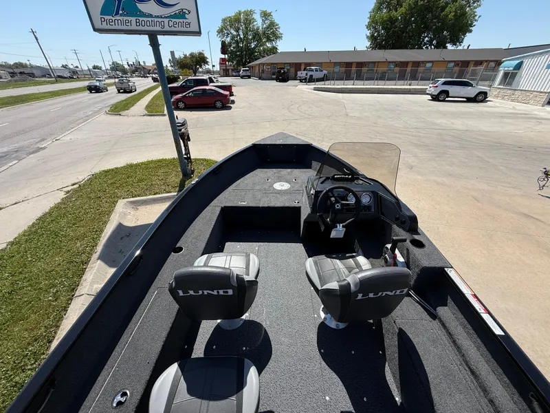 Slide: The Image of 2025 Lund 1650 Rebel XL SS boat at a dealership parking lot. - 4