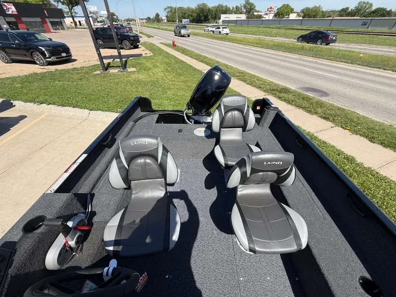 Slide: The Image of 2025 Lund 1650 Rebel XL SS boat with four seats, parked near a road. - 7