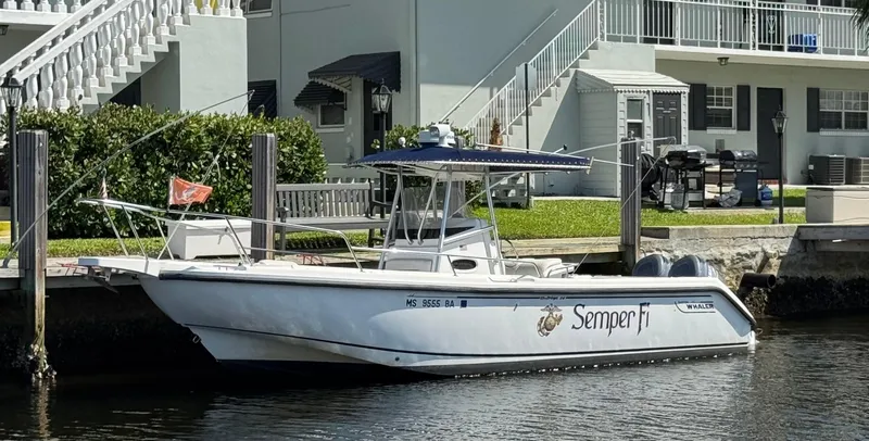 Slide: The Image of 2000 Boston Whaler 26 Outrage boat docked by waterfront property. - 0