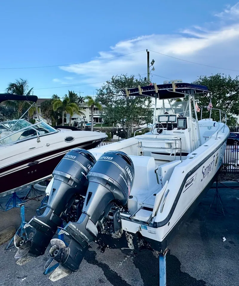 Slide: The Image of 2000 Boston Whaler 26 Outrage boat with dual engines, docked outdoors. - 1