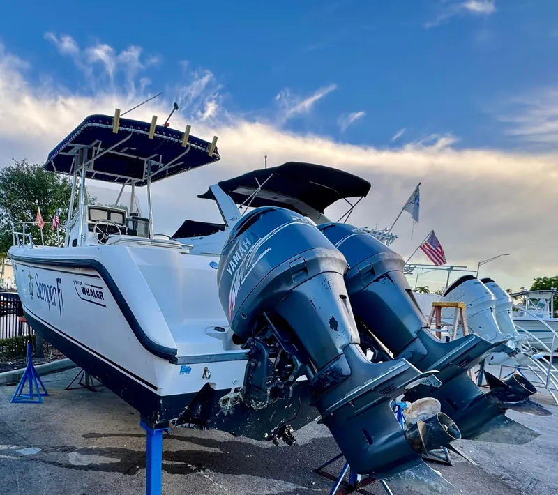 Slide: The Image of Boston Whaler 26 Outrage 2000 with dual Yamaha outboard motors, docked under a blue sky. - 2