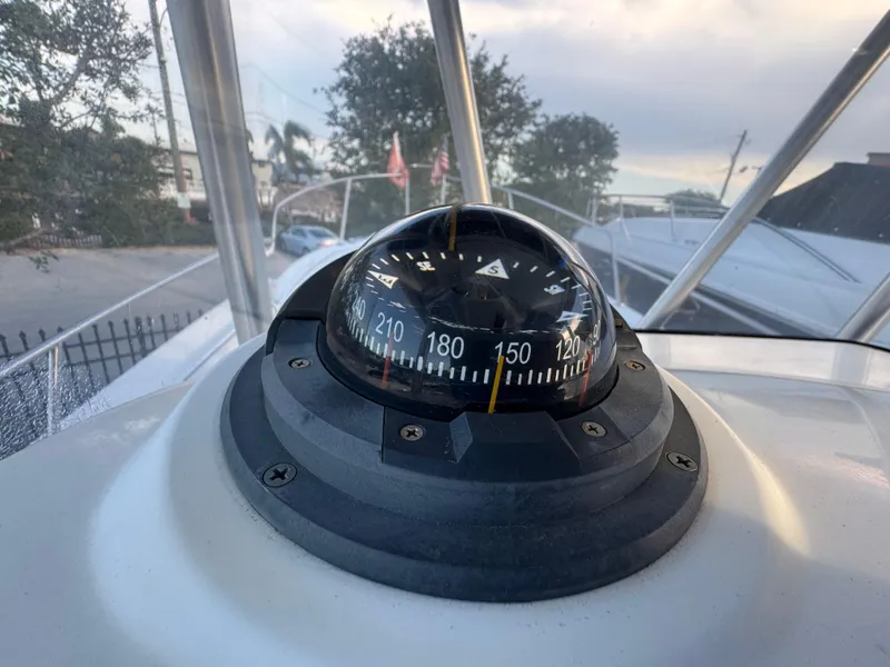 Slide: The Image of Compass on 2000 Boston Whaler 26 Outrage boat, docked with trees in background. - 20