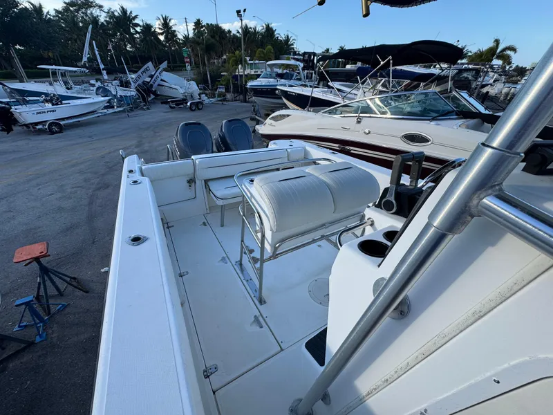 Slide: The Image of 2000 Boston Whaler 26 Outrage boat, docked with other vessels, featuring spacious seating and sleek design. - 22