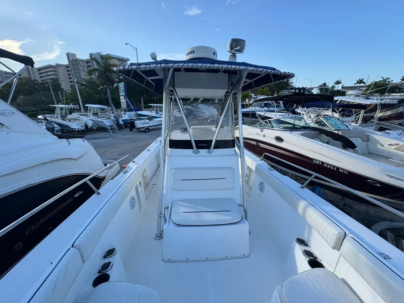 Slide: The Image of Boston Whaler 26 Outrage 2000 model, docked among other boats, clear sky background. - 28