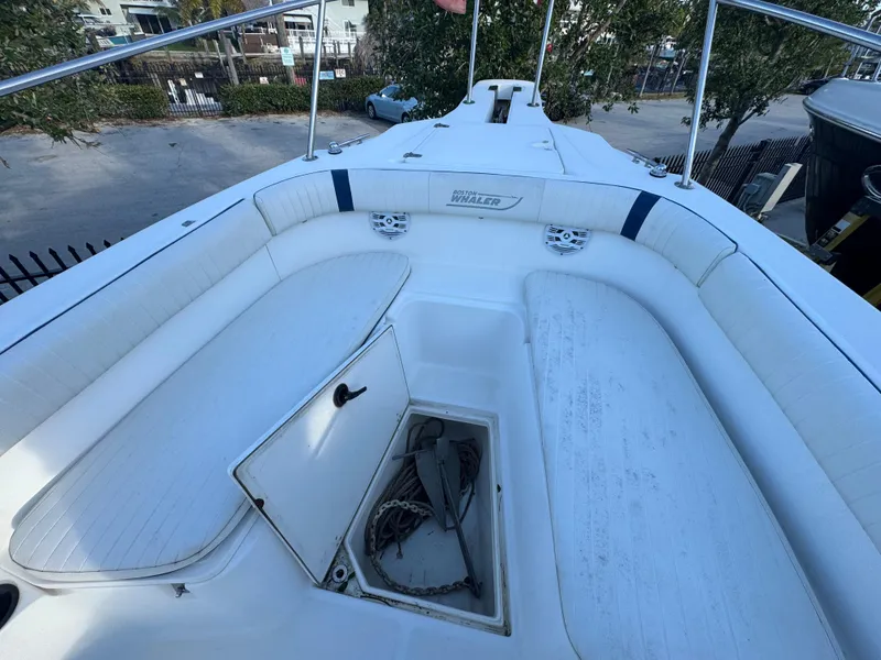 Slide: The Image of 2000 Boston Whaler 26 Outrage boat with open storage compartment and seating area. - 30