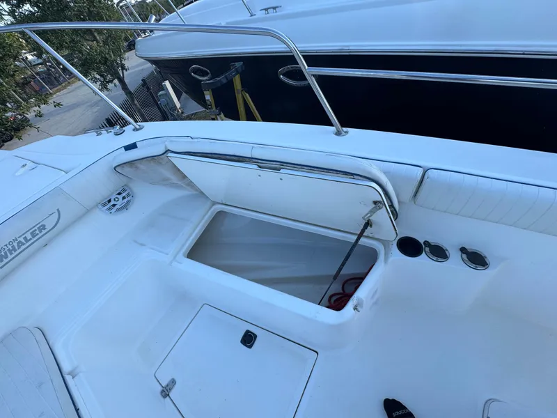 Slide: The Image of Boston Whaler 26 Outrage 2000 model, open storage compartment on deck, white interior. - 32