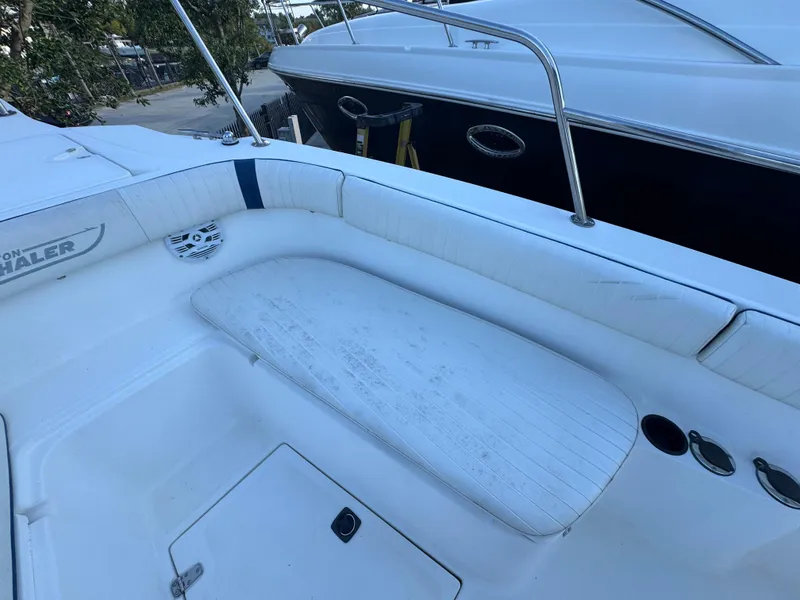 Slide: The Image of Boston Whaler 26 Outrage 2000 boat interior with white seating and storage compartment. - 36