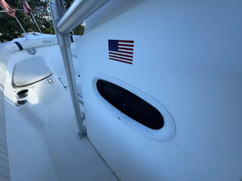 Slide: The Image of 2000 Boston Whaler 26 Outrage boat with American flag decal on white hull. - 39
