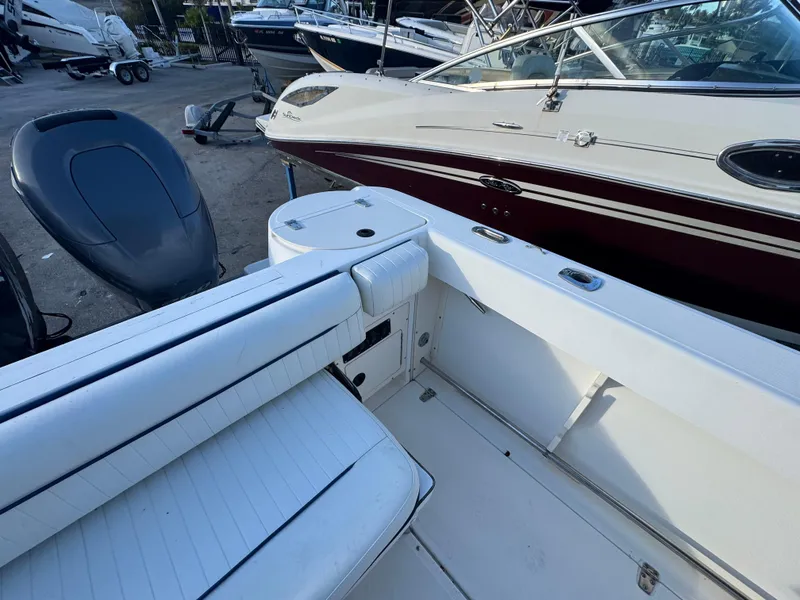 Slide: The Image of Boston Whaler 26 Outrage 2000 model, white interior, docked alongside another boat. - 42