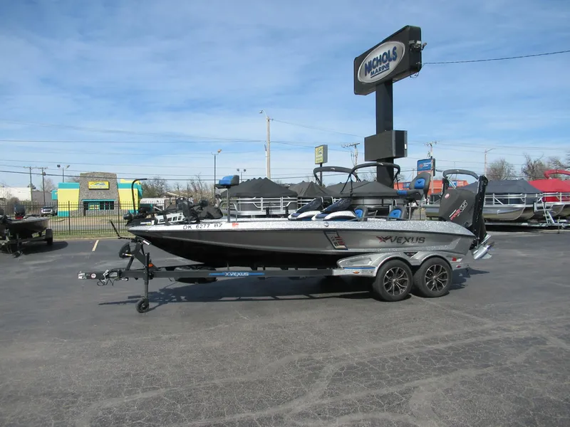 Slide: The Image of 2021 Vexus VX20 boat on trailer at dealership parking lot under clear sky. - 1