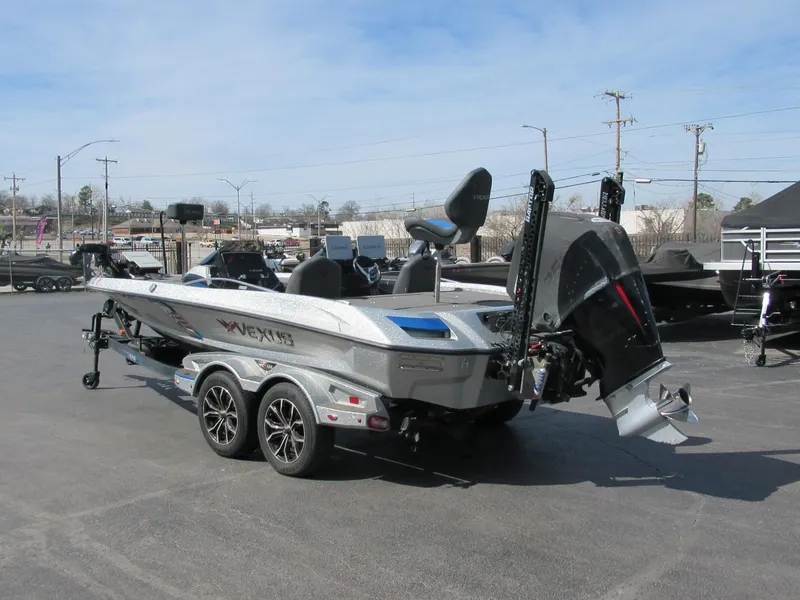 Slide: The Image of 2021 Vexus VX20 boat on trailer, parked outdoors, showcasing sleek design and powerful engine. - 2