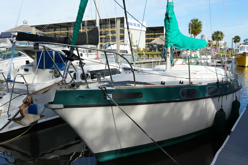 The Image of 1974 Morgan 33 Out Island sailboat docked at marina, featuring green accents and rigging. - 1