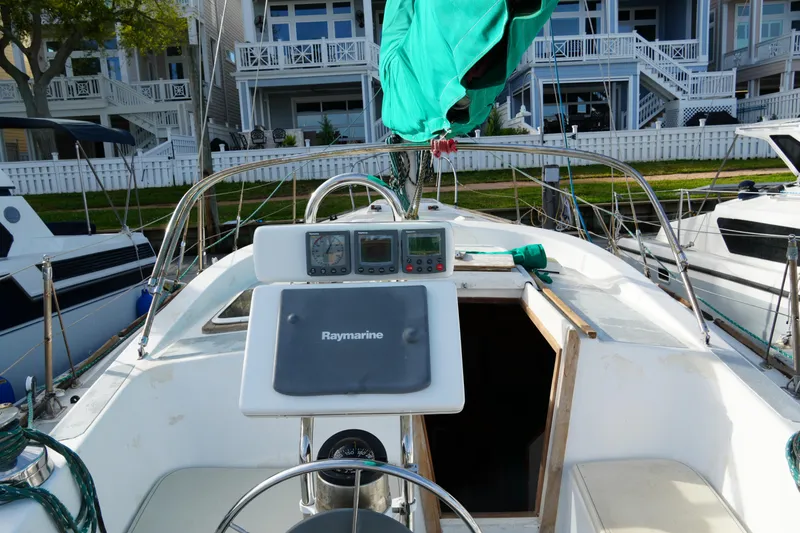 Slide: The Image of 1974 Morgan 33 Out Island sailboat with Raymarine navigation, docked near waterfront homes. - 11