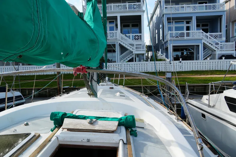 Slide: The Image of 1974 Morgan 33 Out Island sailboat docked near waterfront homes. - 13