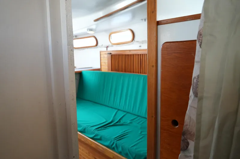 Slide: The Image of 1974 Morgan 33 Out Island interior with green cushioned seating and wooden accents. - 20