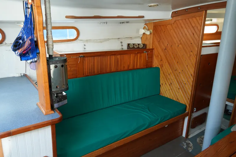 Slide: The Image of 1974 Morgan 33 Out Island interior with green seating and wooden paneling. - 22